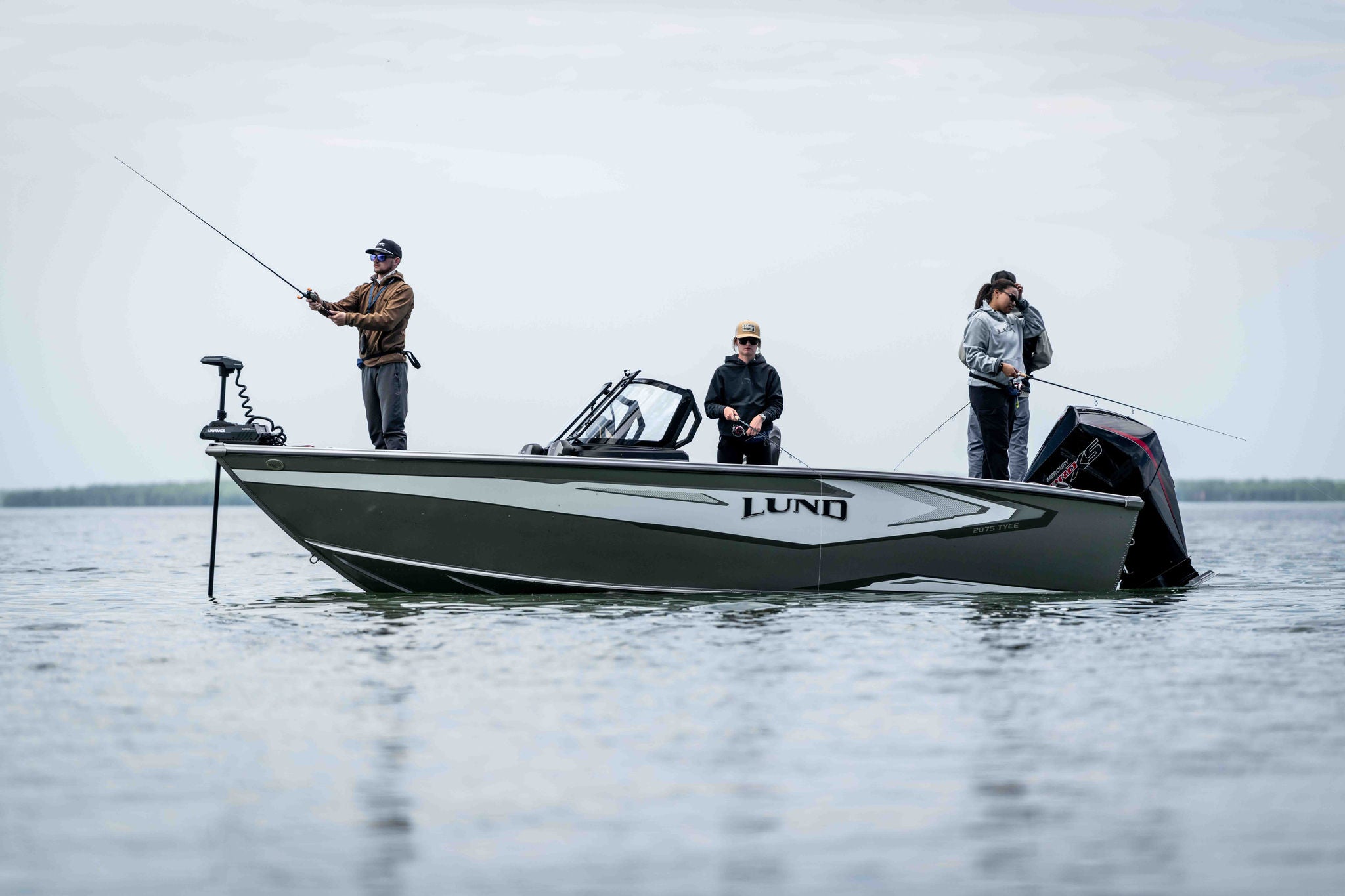 Three people fishing off of a Lund 2075 Tyee