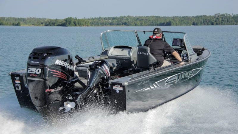 A boat flying across the water at high speeds with a huge wake behind it.