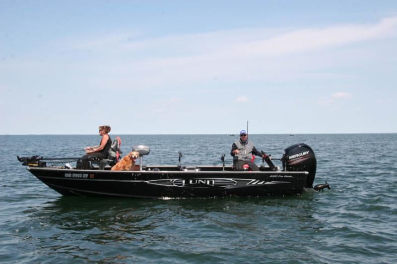 Couple with Golden Retriever Fishing on Lund Boat